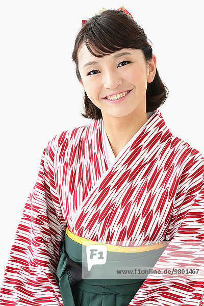 Young Japanese girl in a kimono against white background
