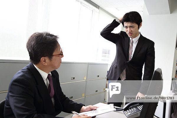 Young Japanese businessman working with his boss