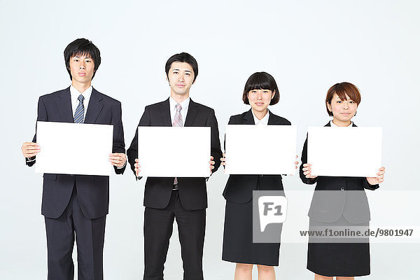 Young Japanese business people holding white boards