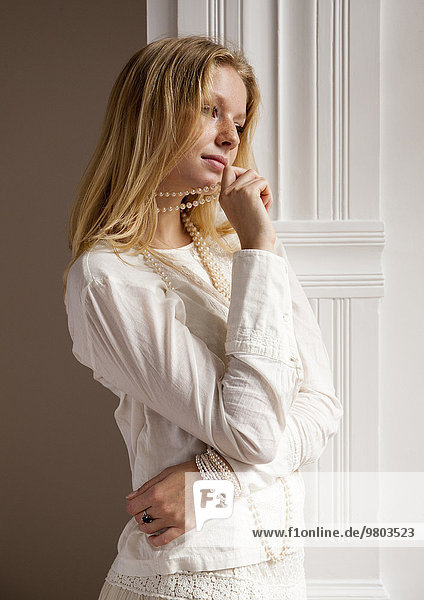 Junge blonde Frau in weißem Kleid