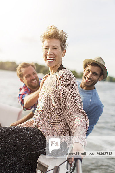 Porträt einer glücklichen Frau  die mit Freunden auf der Yacht genießt.