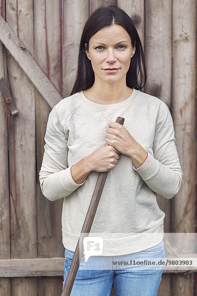 Porträt einer selbstbewussten Bäuerin vor einer Holztür
