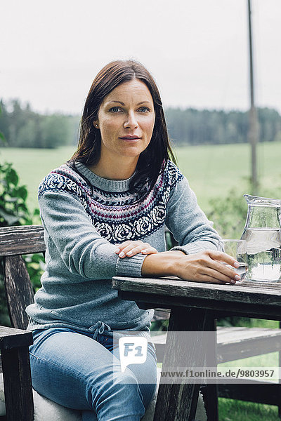 Porträt einer selbstbewussten Frau am Tisch im Bio-Bauernhof