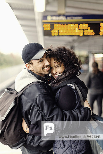 Seitenansicht Porträt eines glücklichen Paares  das sich in der U-Bahn umarmt.