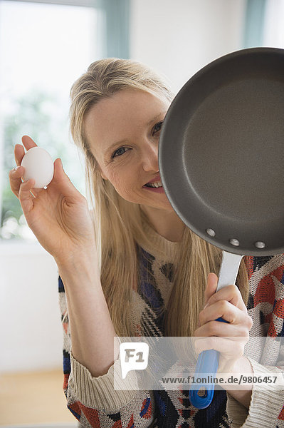 Woman holding frying pan and egg