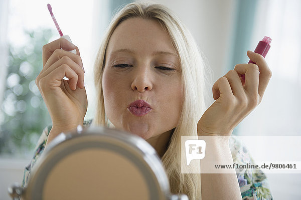 Woman applying lipgloss