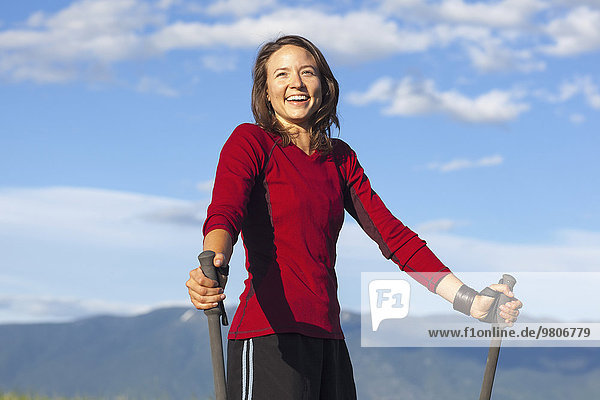 Portrait of smiling woman with trekking poles