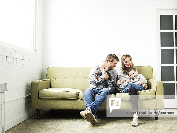 Family embracing on sofa