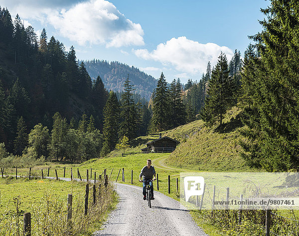 Young man riding a bicycle  mountain landscape  Valepptal  Spitzingsee  Bavaria  Germany  Europe