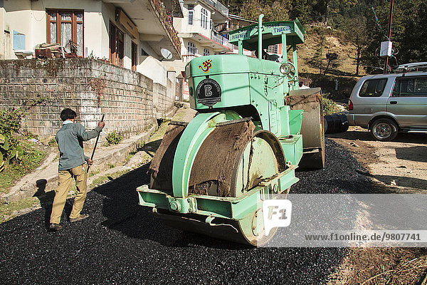 Straßenbauarbeiter im Teer  Walze rollt über frischen Asphalt  Tota Rani  Dharamsala  Himal Pradesh  Indien  Asien