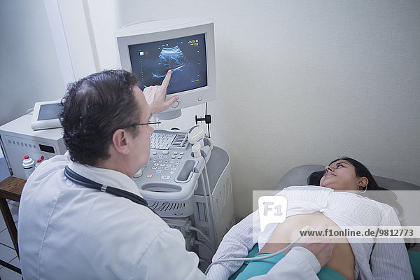 Sonographin und junge Frau beim Betrachten des Ultraschalls am Computerbildschirm
