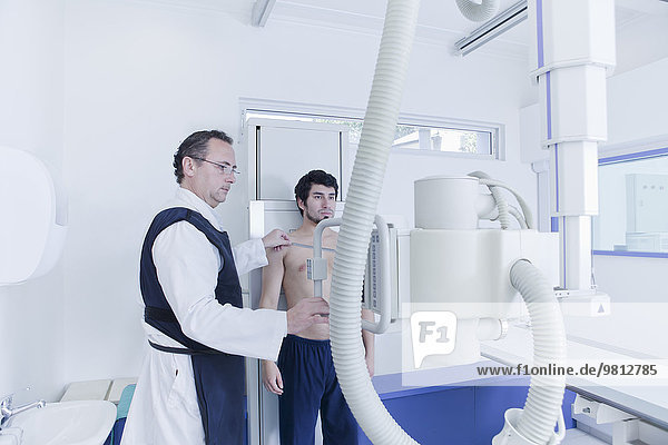 Röntgentechniker bei der Vorbereitung des Röntgengerätes im Stehen