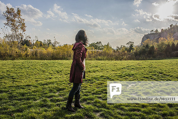 Mid adult woman standing on grass  looking away