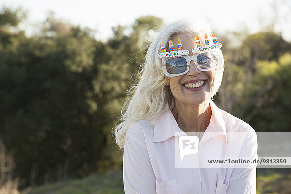 Senior woman wearing party glasses  Hahn Park  Los Angeles  California  USA