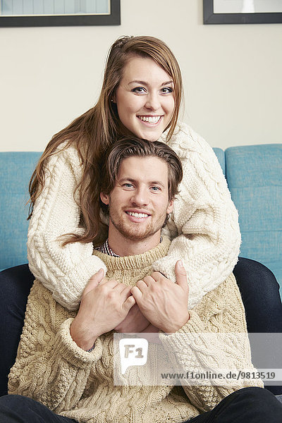 Portrait of young couple wearing his and hers knitted sweaters