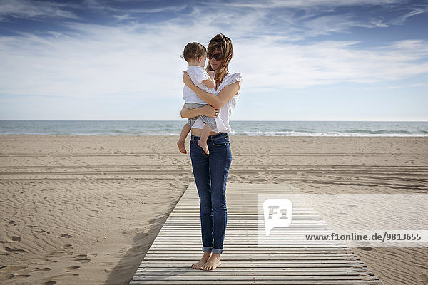 Mid adult woman and toddler daughter on beach  Castelldefels  Catalonia  Spain