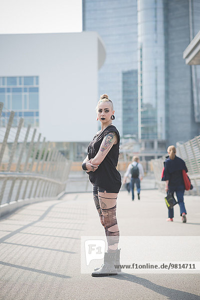 Portrait of young female tattooed punk on street