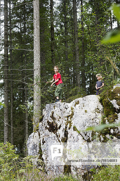 Geschwister spielen auf Felsformationen im Wald  Zauberwald  Bayern  Deutschland