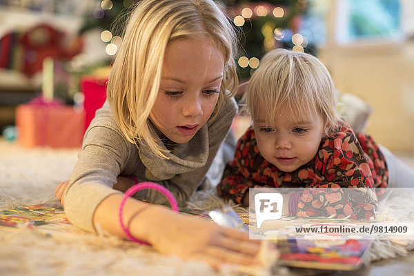 Schwestern schauen auf den Adventskalender