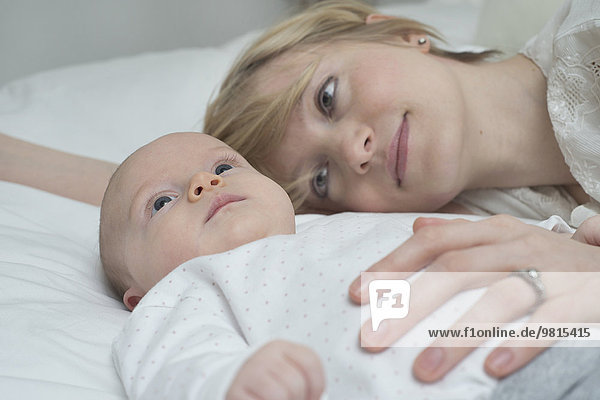 Mother with baby girl on bed