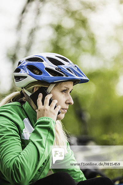 Junge Radfahrerin im Chat auf dem Smartphone  Augsburg  Bayern  Deutschland