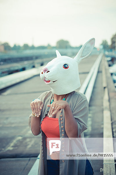 Junge Frau in Kaninchenkostüm Maske im städtischen Industriegebiet