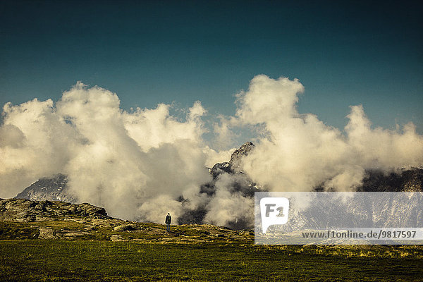 Frankreich  Lombardei  bei Chiareggio  Blick auf wolkenverhangene Alpen  einsamer Mann