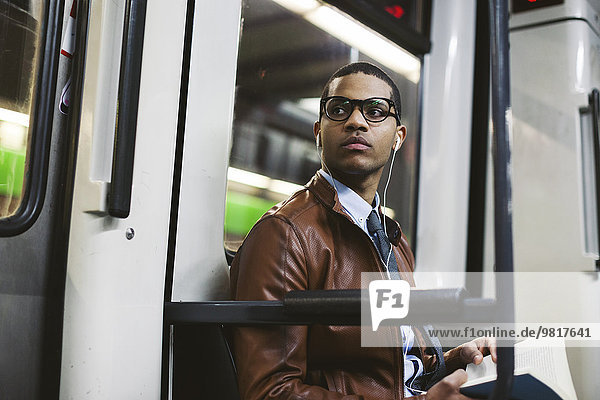 Businessman with book on the subway train