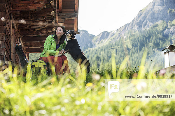 Austria  Altenmarkt-Zauchensee  young woman with dog at alpine cabin