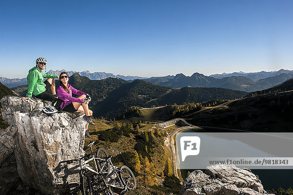 Österreich  Altenmarkt-Zauchensee  junges Paar mit Mountainbikes in den Bergen