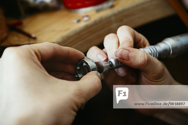 Goldsmith polishing wedding rings in Mokume Gane style
