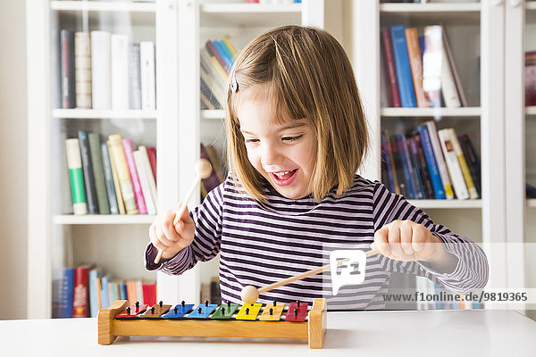 Portrait of happy little girl playing xylophones
