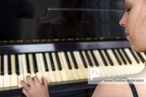 Frau spielt altes Klavier