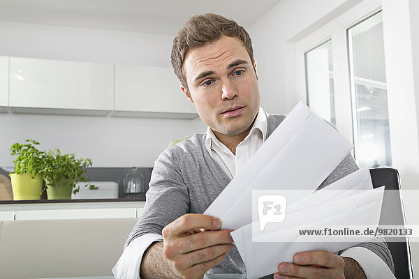 Man sitting in kitchen watching letters