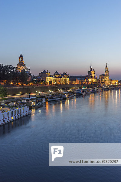 Deutschland  Dresden  Blick auf die beleuchtete Altstadt mit der Elbe im Vordergrund am Abend