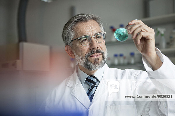 Wissenschaftler im Labor zur Untersuchung von Flüssigkeit in Rundkolben