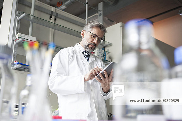 Wissenschaftler mit digitalem Tablett im Labor