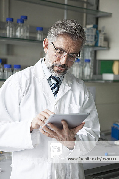 Wissenschaftler mit digitalem Tablett im Labor