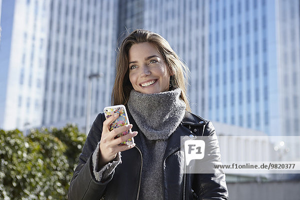 Deutschland  Düsseldorf  Junge Frau mit Smartphone
