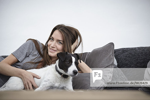 Young woman relaxing with dog on couch