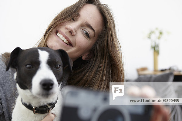 Young woman taking selfie with dog
