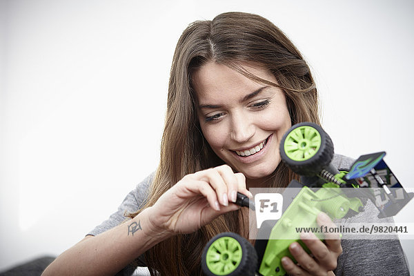 Young woman repairing toy car