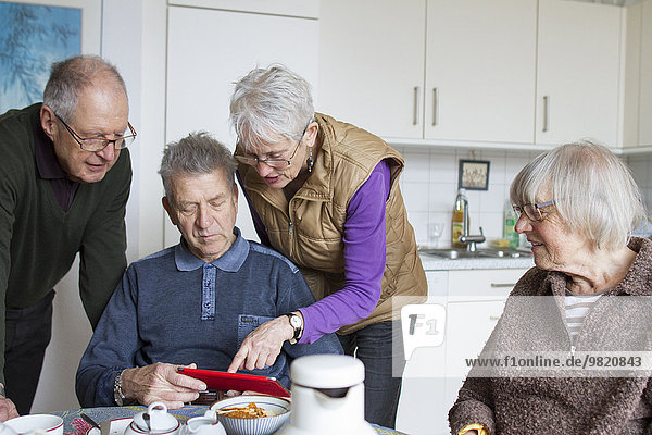 Senioren einer Wohngemeinschaft mit digitalem Tablett