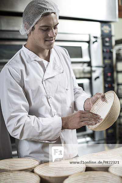 Bäcker bereitet Keramikschalen zum Brotbacken vor
