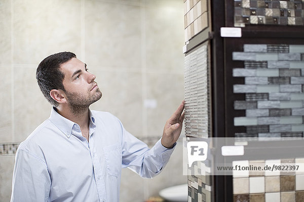 Man looking at tile samples in a bathroom shop