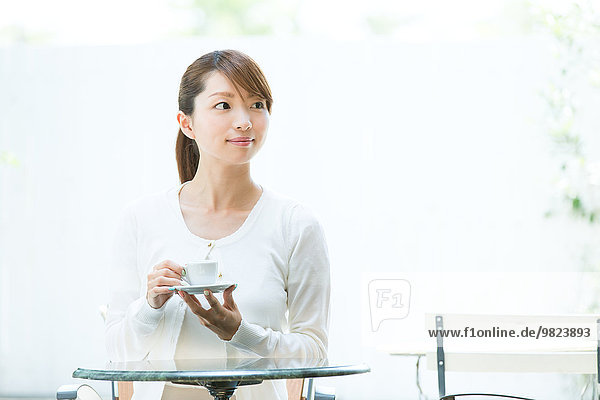 Attractive young girl having coffee outside