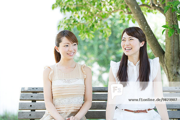 Attractive young girls sitting in a park