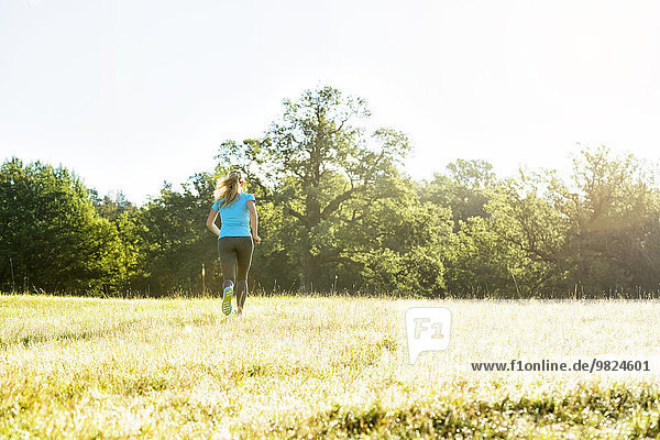 Woman jogging through meadow