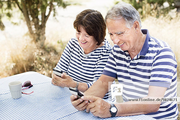 Mature couple with cell phones