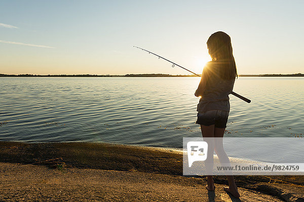 Girl fishing in sea  dusk